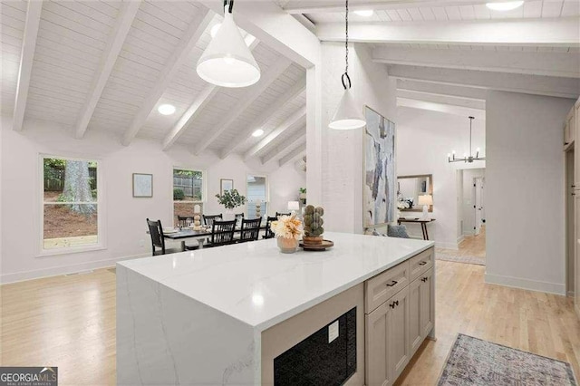 6405 Cherry Tree Ln, Atlanta, GA 30328 - kitchen featuring light wood-style flooring, light countertops, decorative light fixtures, a center island, and wooden ceiling