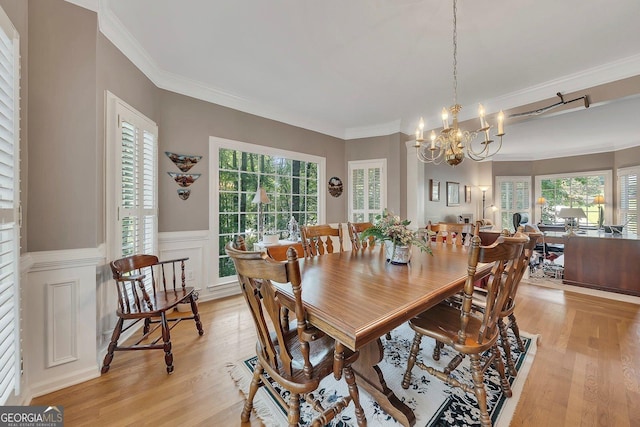 6302 Manassas Pass NW, Acworth, GA 30101 - dining area featuring light wood-style flooring, healthy amount of natural light, a chandelier, a wainscoted wall, and crown molding