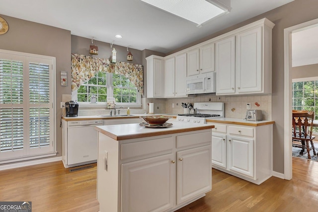 6302 Manassas Pass NW, Acworth, GA 30101 - kitchen with white appliances, light wood-style floors, light countertops, white cabinets, and backsplash