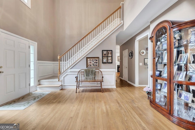 6302 Manassas Pass NW, Acworth, GA 30101 - entrance foyer featuring wood finished floors, stairs, healthy amount of natural light, a wainscoted wall, and a high ceiling