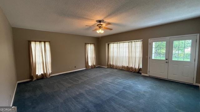279 Baker Cir SE, Calhoun, GA 30701 - unfurnished living room with healthy amount of natural light, ceiling fan, dark carpet, and a textured ceiling