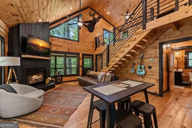 25 Hidden Ridge Ct, Cherry Log, GA 30522 - living room featuring wood walls, wood-type flooring, high vaulted ceiling, a fireplace, and stairs