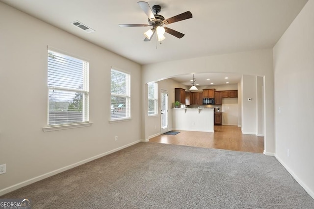203 Creek View Ln, Acworth, GA 30102 - unfurnished living room featuring light carpet, arched walkways, a ceiling fan, and recessed lighting