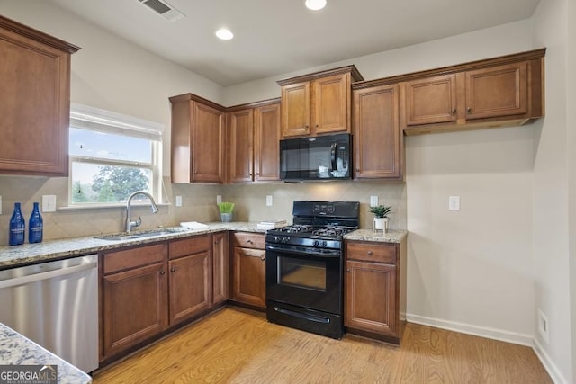 203 Creek View Ln, Acworth, GA 30102 - kitchen with black appliances, light wood-style floors, light stone counters, recessed lighting, and brown cabinetry
