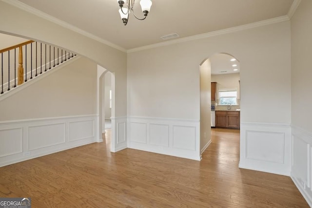 203 Creek View Ln, Acworth, GA 30102 - spare room featuring wood finished floors, a wainscoted wall, arched walkways, crown molding, and a chandelier