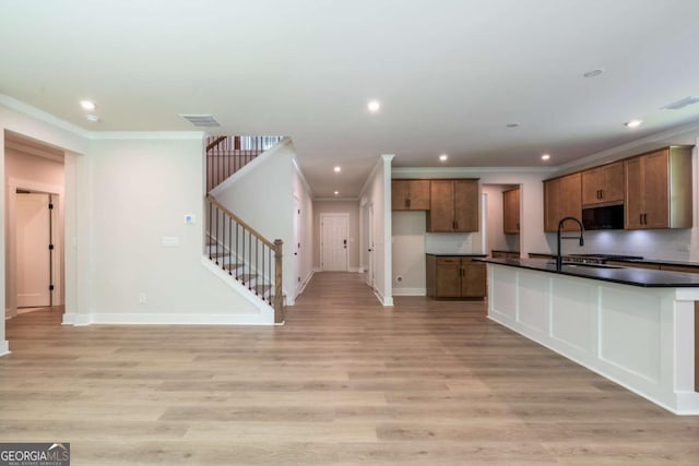 106 Henley St, Canton, GA 30114 - kitchen featuring dark countertops, brown cabinetry, crown molding, light wood-type flooring, and recessed lighting