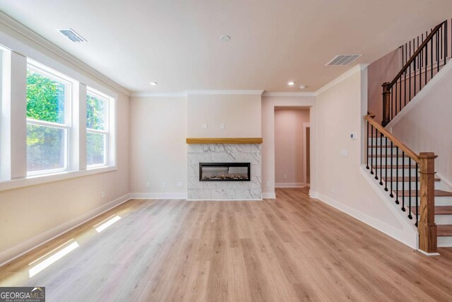 106 Henley St, Canton, GA 30114 - unfurnished living room with light wood finished floors, ornamental molding, a fireplace, stairway, and recessed lighting
