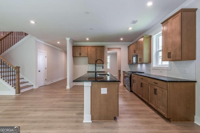 106 Henley St, Canton, GA 30114 - kitchen featuring stainless steel range with gas stovetop, black microwave, plenty of natural light, brown cabinetry, and crown molding