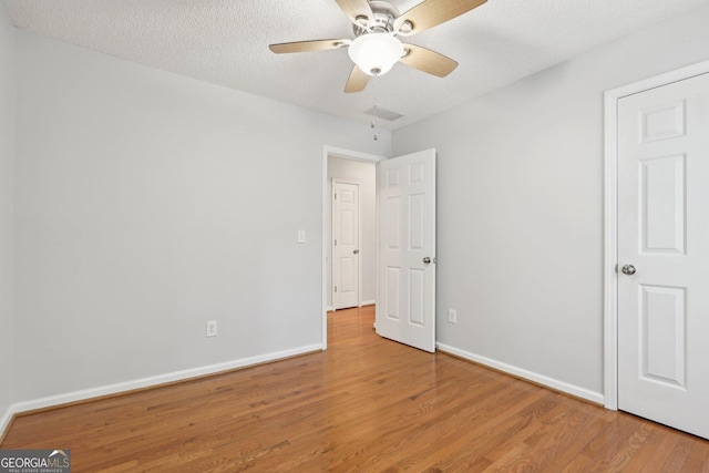 3850 Stepney Way, Cumming, GA 30041 - unfurnished bedroom with wood finished floors, a textured ceiling, and a ceiling fan