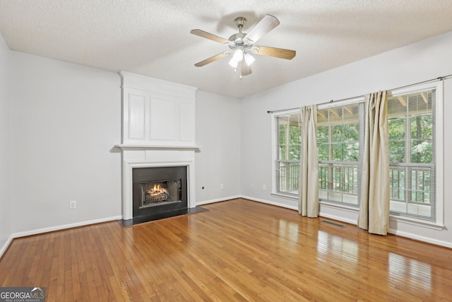 3850 Stepney Way, Cumming, GA 30041 - unfurnished living room with light wood-type flooring, a fireplace, a ceiling fan, and a textured ceiling