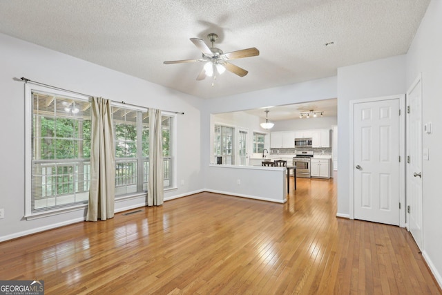 3850 Stepney Way, Cumming, GA 30041 - unfurnished living room featuring a ceiling fan, light wood-style floors, and a textured ceiling
