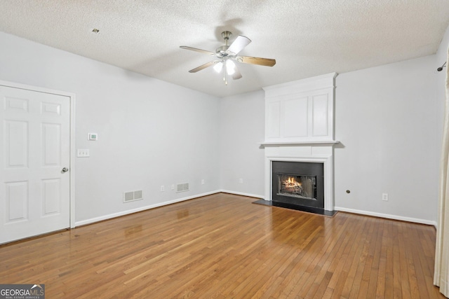 3850 Stepney Way, Cumming, GA 30041 - unfurnished living room featuring hardwood / wood-style flooring, ceiling fan, a fireplace, and a textured ceiling