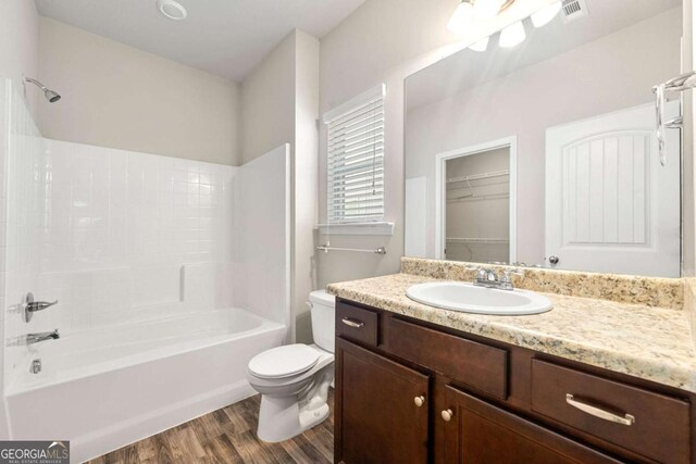 175 Orchard Ln, Covington, GA 30014 - full bath featuring toilet, vanity, wood finished floors, shower / bathtub combination, and a spacious closet