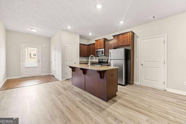 175 Orchard Ln, Covington, GA 30014 - kitchen with stainless steel appliances, light wood-style floors, light stone countertops, baseboards, and recessed lighting