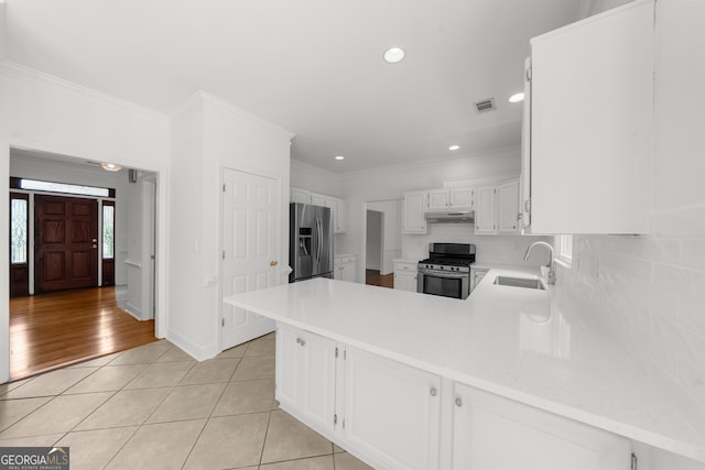 10865 Misty Moon Ct, Alpharetta, GA 30022 - kitchen with appliances with stainless steel finishes, a sink, under cabinet range hood, backsplash, and a peninsula