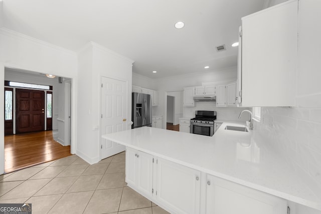 10865 Misty Moon Ct, Alpharetta, GA 30022 - kitchen with stainless steel appliances, under cabinet range hood, backsplash, a peninsula, and ornamental molding