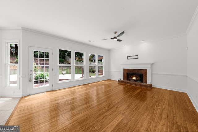 10865 Misty Moon Ct, Alpharetta, GA 30022 - unfurnished living room with ceiling fan, a brick fireplace, crown molding, light wood-style flooring, and baseboards