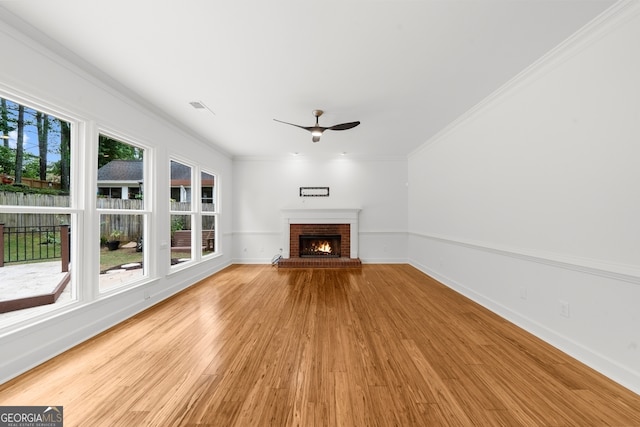 10865 Misty Moon Ct, Alpharetta, GA 30022 - unfurnished living room featuring a ceiling fan, light wood-style flooring, baseboards, a brick fireplace, and crown molding