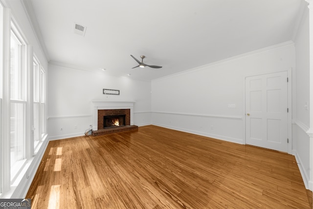 10865 Misty Moon Ct, Alpharetta, GA 30022 - unfurnished living room with ceiling fan, a brick fireplace, light wood-style floors, baseboards, and crown molding