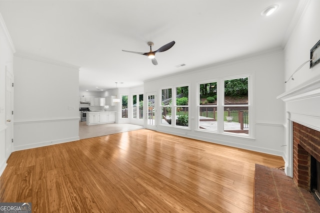 10865 Misty Moon Ct, Alpharetta, GA 30022 - unfurnished living room featuring a brick fireplace, ceiling fan, crown molding, light wood-type flooring, and baseboards