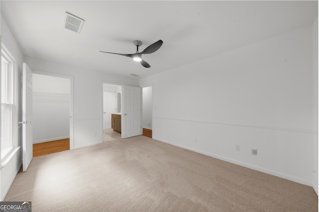 10865 Misty Moon Ct, Alpharetta, GA 30022 - unfurnished bedroom featuring light carpet, a walk in closet, ensuite bathroom, a closet, and a ceiling fan