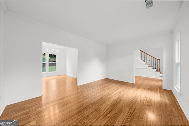 10865 Misty Moon Ct, Alpharetta, GA 30022 - unfurnished living room featuring ornamental molding, stairs, light wood finished floors, a chandelier, and baseboards