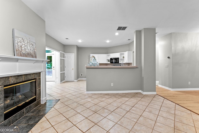 205 N Strathmore Dr, Sharpsburg, GA 30277 - unfurnished living room featuring a tiled fireplace, light tile patterned floors, baseboards, and recessed lighting