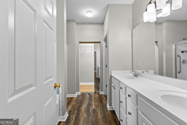 205 N Strathmore Dr, Sharpsburg, GA 30277 - bathroom with a shower stall, wood finished floors, double vanity, a walk in closet, and baseboards