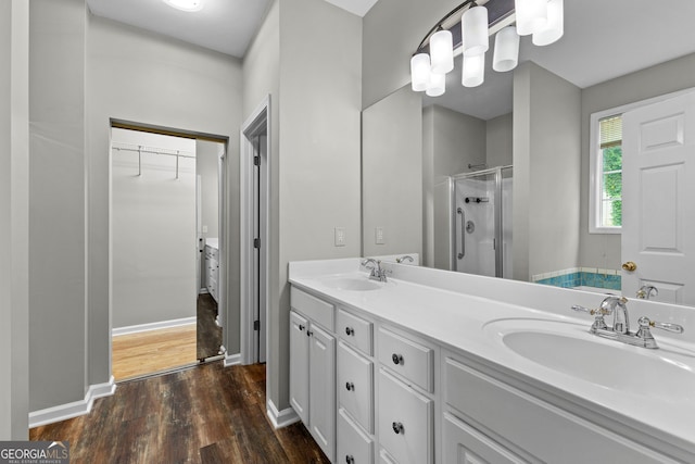 205 N Strathmore Dr, Sharpsburg, GA 30277 - full bathroom with a shower stall, wood finished floors, double vanity, a spacious closet, and baseboards