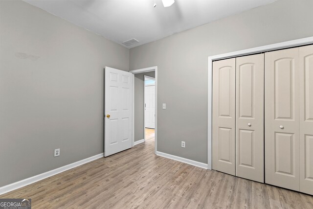205 N Strathmore Dr, Sharpsburg, GA 30277 - unfurnished bedroom with light wood-style flooring, baseboards, and a closet
