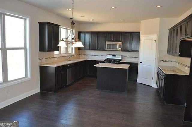 920 Crescent Ridge Dr, Buford, GA 30518 - kitchen featuring stainless steel microwave, gas stove, decorative backsplash, a center island, and recessed lighting