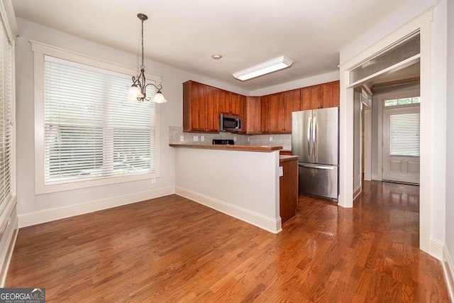 65 Orchard Dr, Covington, GA 30014 - kitchen with stainless steel appliances, baseboards, a chandelier, and a peninsula