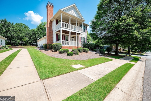 65 Orchard Dr, Covington, GA 30014 - greek revival house with a balcony, a chimney, a porch, and a front yard