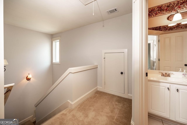 65 Orchard Dr, Covington, GA 30014 - hall featuring an upstairs landing, attic access, light colored carpet, baseboards, and a sink
