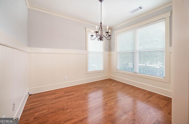 65 Orchard Dr, Covington, GA 30014 - spare room with wood finished floors, a chandelier, wainscoting, healthy amount of natural light, and baseboards
