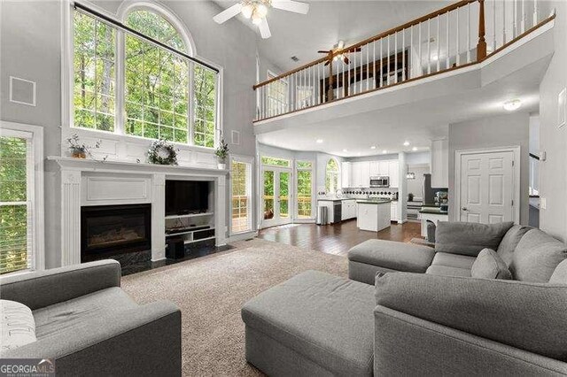 2342 Tall Timbers Ln, Marietta, GA 30066 - living room with a high ceiling, a ceiling fan, a fireplace with flush hearth, and plenty of natural light