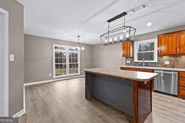 810 Callaway Church Rd, Lagrange, GA 30241 - kitchen with stainless steel dishwasher, a chandelier, a center island, light wood-style floors, and backsplash