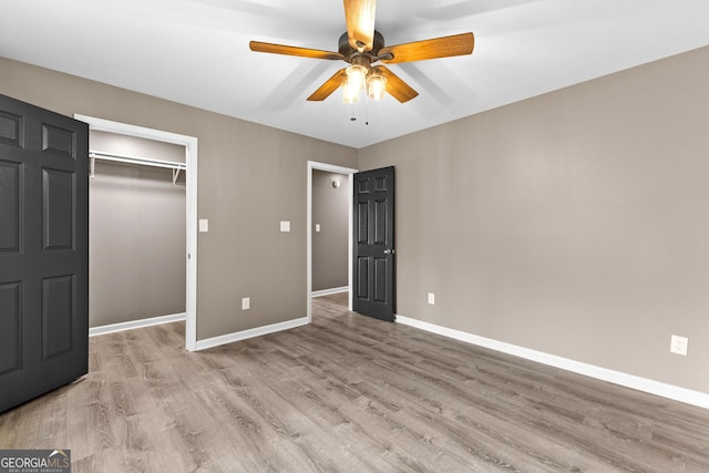 810 Callaway Church Rd, Lagrange, GA 30241 - unfurnished bedroom featuring light wood finished floors, a closet, a ceiling fan, and a walk in closet