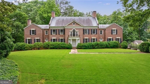 280 Blackland Rd NW, Atlanta, GA 30342 - colonial inspired home featuring a chimney, a front lawn, and view of scattered trees