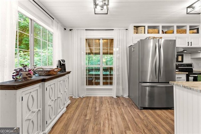 437 Jewell Slaton Rd, Dawsonville, GA 30534 - kitchen featuring appliances with stainless steel finishes, under cabinet range hood, white cabinets, light wood finished floors, and healthy amount of natural light