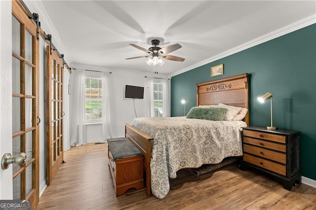 437 Jewell Slaton Rd, Dawsonville, GA 30534 - bedroom featuring crown molding, wood finished floors, a barn door, a ceiling fan, and baseboards