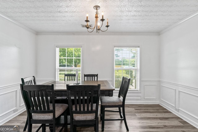 11581 Kades Trl, Hampton, GA 30228 - dining space with a chandelier, wood finished floors, a wainscoted wall, ornamental molding, and a decorative wall