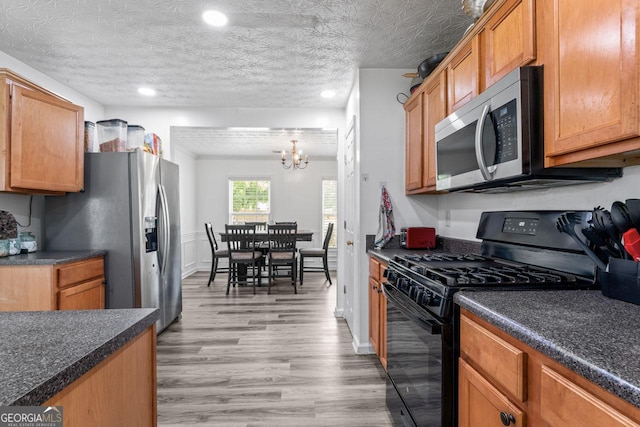 11581 Kades Trl, Hampton, GA 30228 - kitchen featuring stainless steel appliances, a chandelier, dark countertops, light wood-type flooring, and recessed lighting