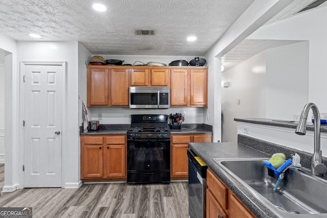 11581 Kades Trl, Hampton, GA 30228 - kitchen with stainless steel microwave, a sink, black gas range oven, dishwasher, and dark countertops
