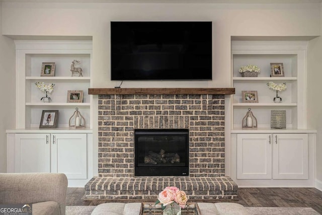 7345 Vale Ct, Cumming, GA 30028 - living area with built in shelves, a brick fireplace, and dark wood-style floors