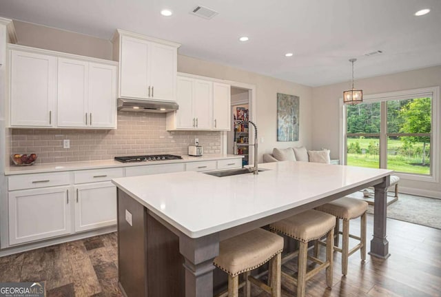 7345 Vale Ct, Cumming, GA 30028 - kitchen with a sink, under cabinet range hood, light countertops, recessed lighting, and dark wood-style floors