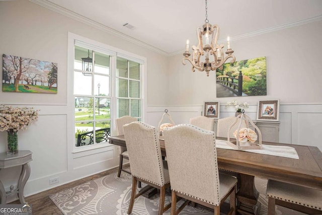 7345 Vale Ct, Cumming, GA 30028 - dining area featuring a chandelier, a decorative wall, ornamental molding, wood finished floors, and wainscoting