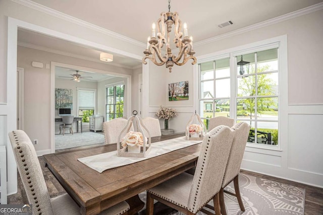 7345 Vale Ct, Cumming, GA 30028 - dining area featuring dark wood-type flooring, crown molding, a chandelier, a decorative wall, and a wainscoted wall