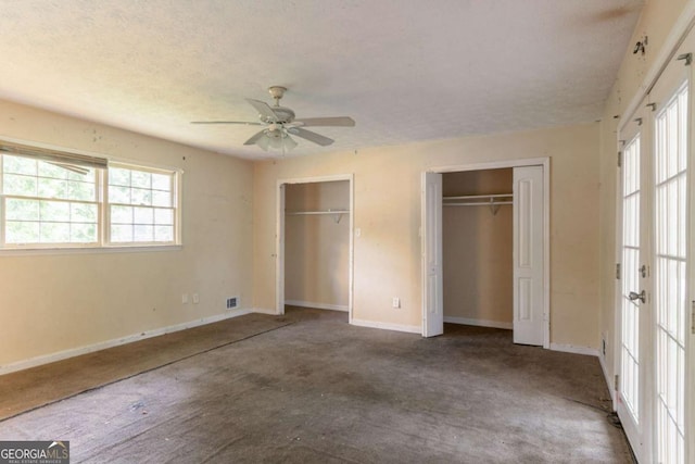 4715 Wildginger Run, Lithonia, GA 30038 - unfurnished bedroom with two closets, carpet floors, baseboards, a textured ceiling, and ceiling fan