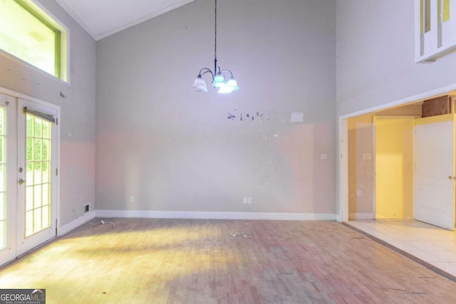 4715 Wildginger Run, Lithonia, GA 30038 - spare room featuring high vaulted ceiling, wood finished floors, a chandelier, and baseboards